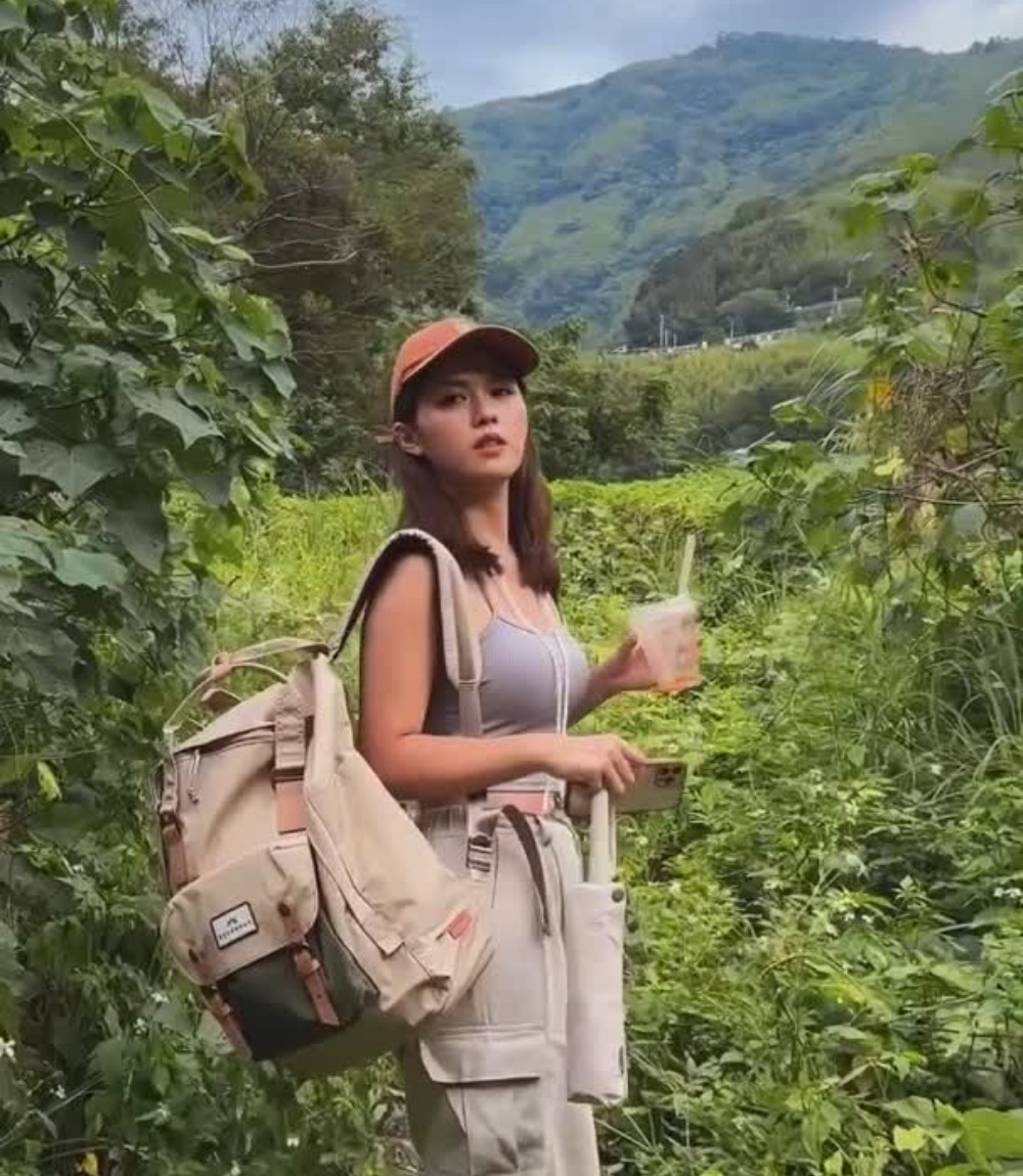 Frau mit Doughnut Rucksack der Jungle Series in grüner Landschaft