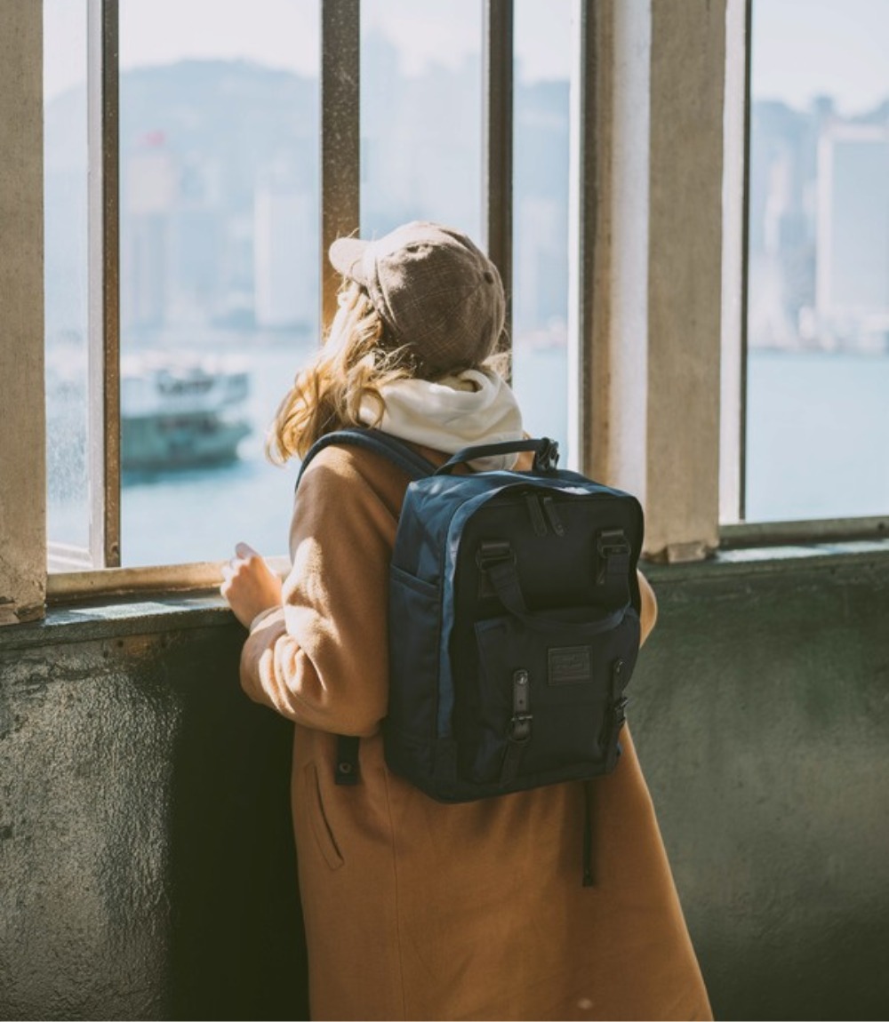 Frau am Fenster mit Doughnut Macaroon Large Rucksack in Dunkelblau